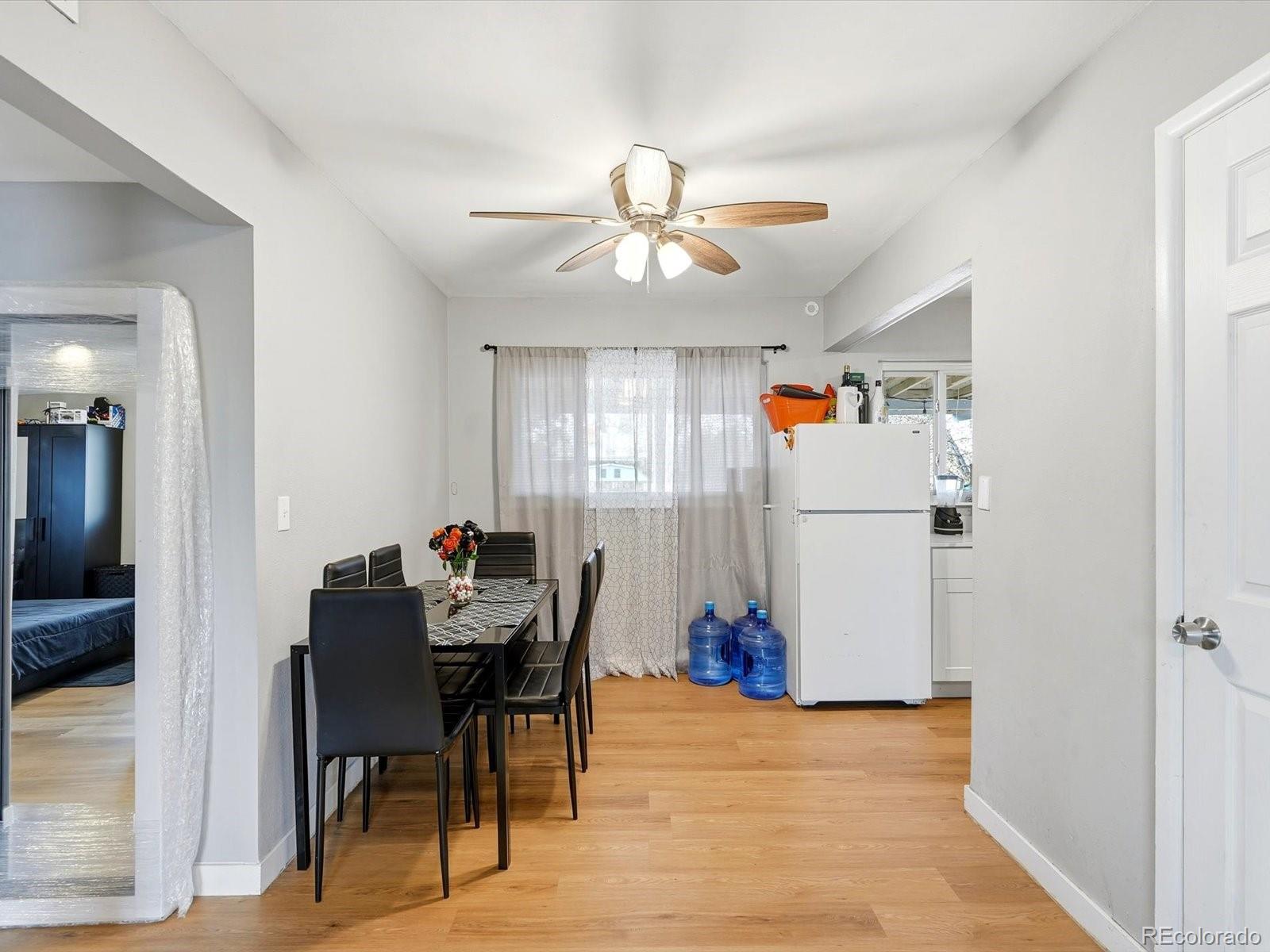 1883 South Perry Way Denver, CO 80219 - Photo 17 of 36 a view of a dining room with furniture and a chandelier fan