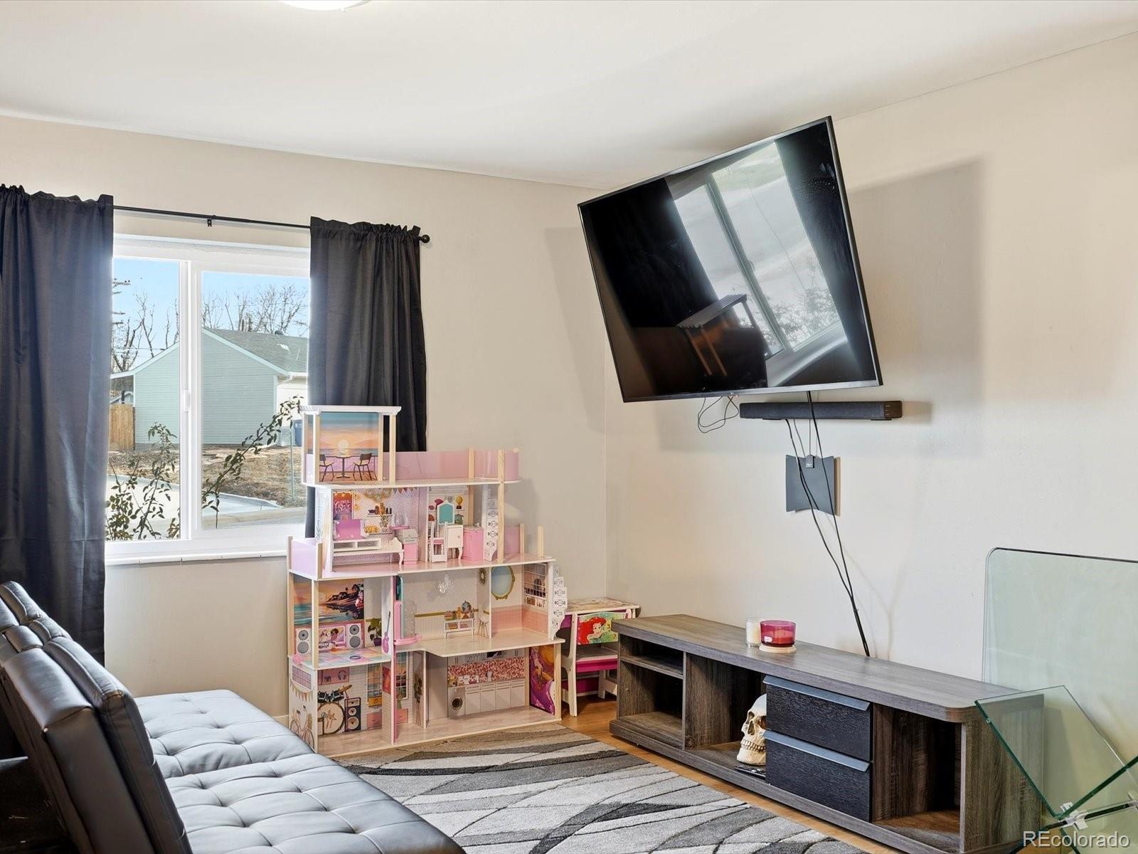1883 South Perry Way Denver, CO 80219 - Photo 19 of 36 a living room with furniture and a flat screen tv