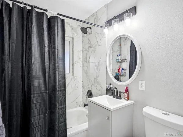 a bathroom with a sink a toilet and a mirror