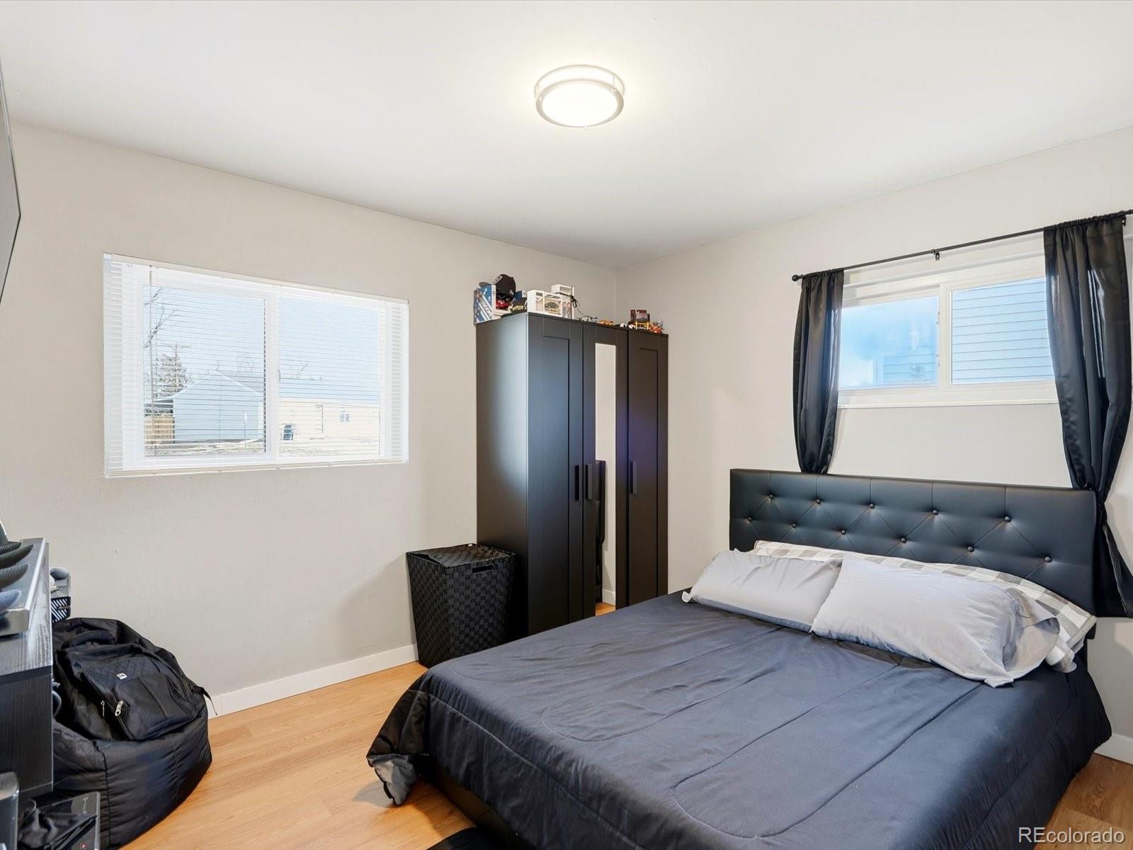 1883 South Perry Way Denver, CO 80219 - Photo 28 of 36 a bedroom with a bed and wooden floor