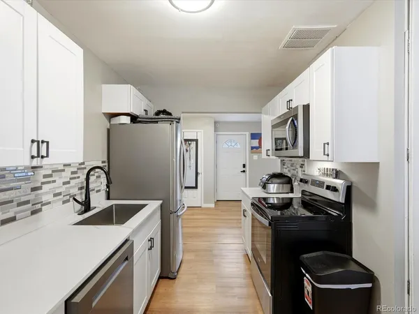 a kitchen with a sink stove and refrigerator