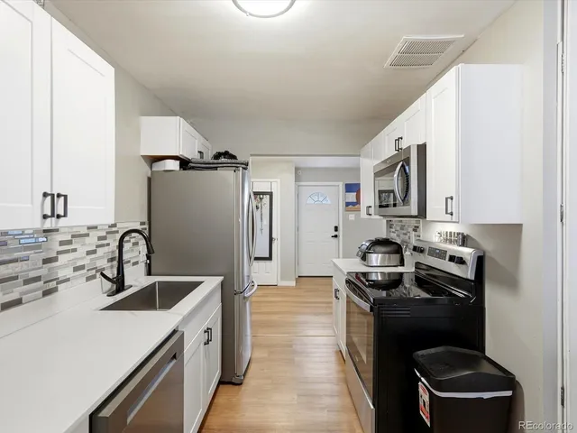 a kitchen with a sink stove and refrigerator
