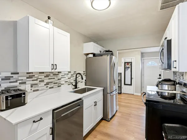 a kitchen with a sink stove and refrigerator