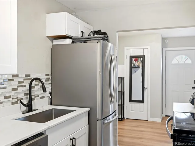 a view of a kitchen with a sink and refrigerator