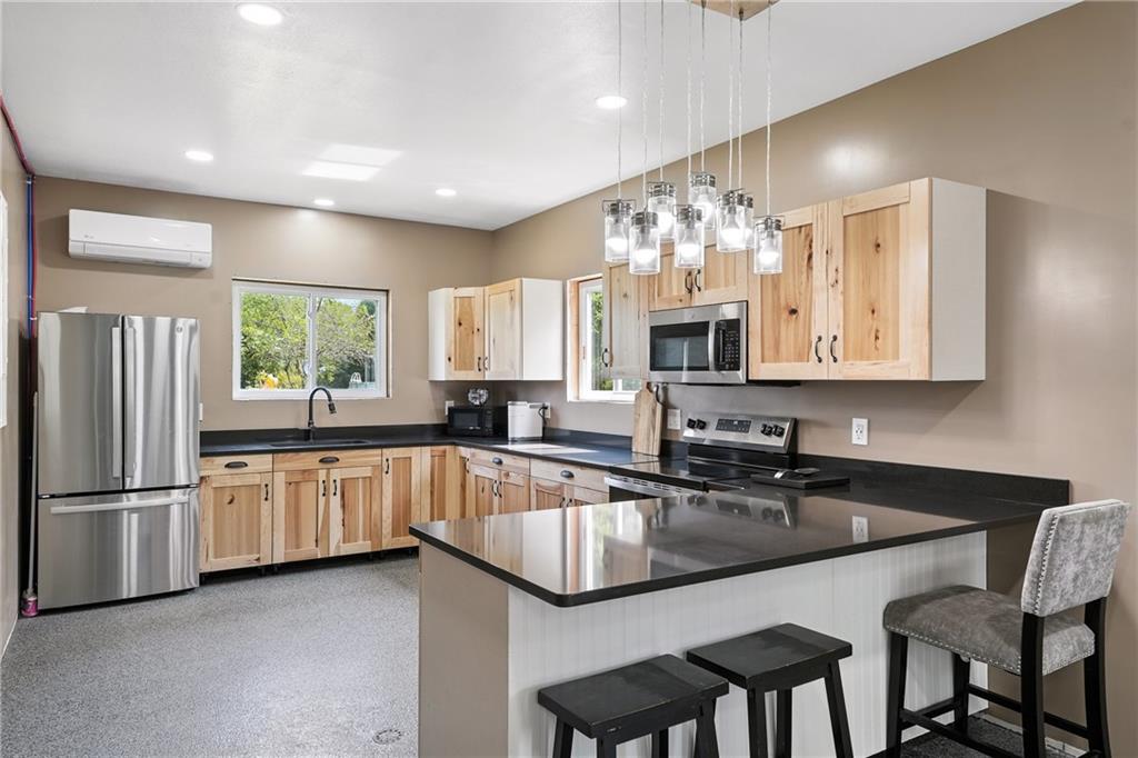 246 Lyons Road Stoneboro, PA 16153 - Photo 28 of 40 a kitchen with granite countertop a sink chairs and refrigerator