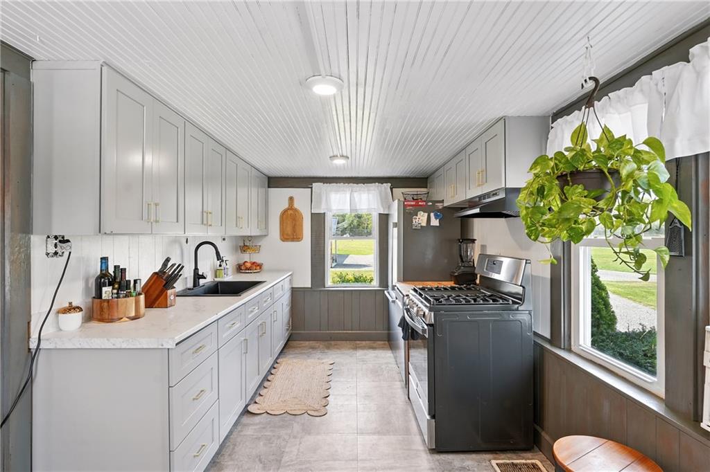246 Lyons Road Stoneboro, PA 16153 - Photo 5 of 40 a kitchen with stainless steel appliances a sink a counter top space and a window