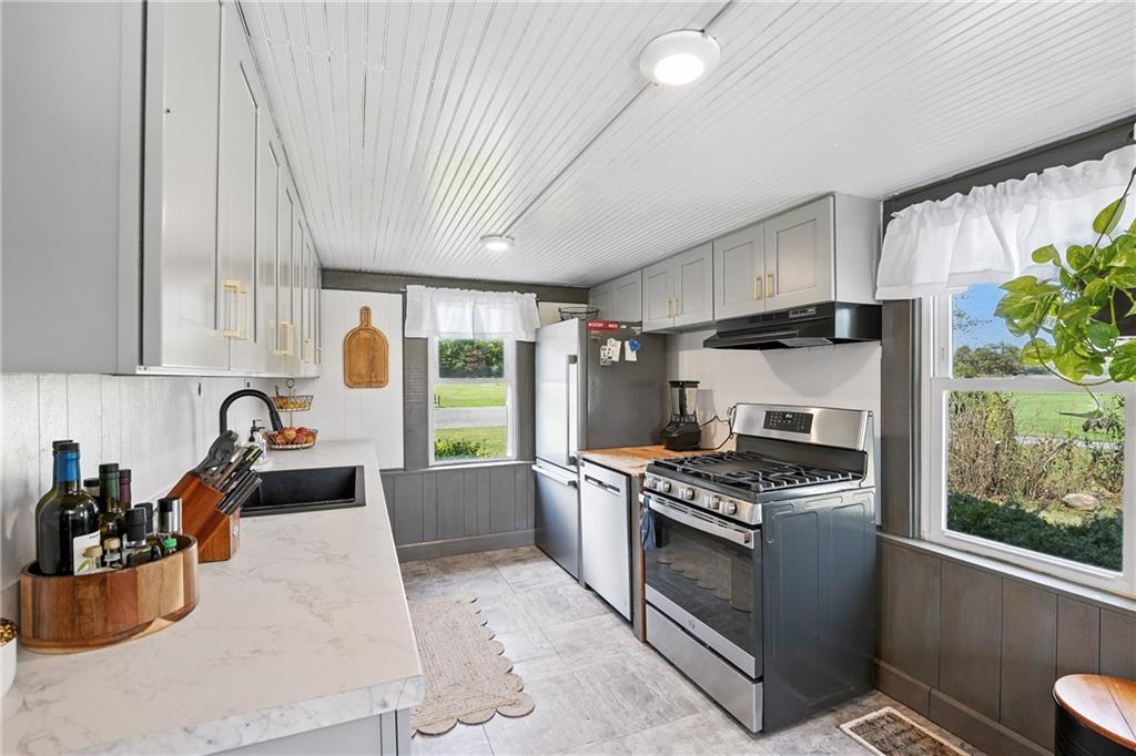 246 Lyons Road Stoneboro, PA 16153 - Photo 6 of 40 a kitchen with stainless steel appliances kitchen island granite countertop a stove a sink and a refrigerator