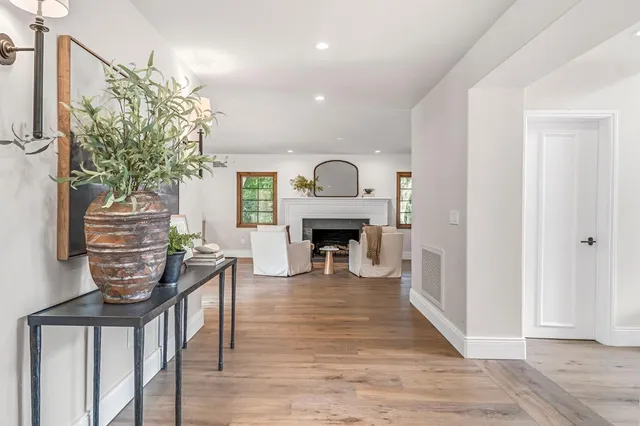 a large white kitchen with a lot of counter space and a wooden floor