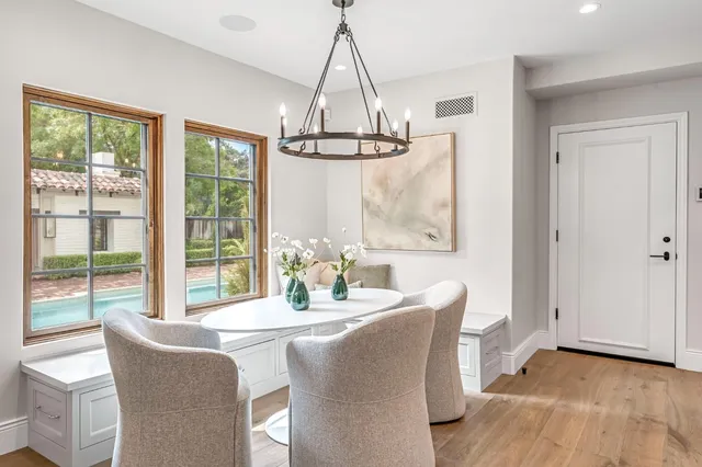 an empty room with windows fireplace and wooden floor