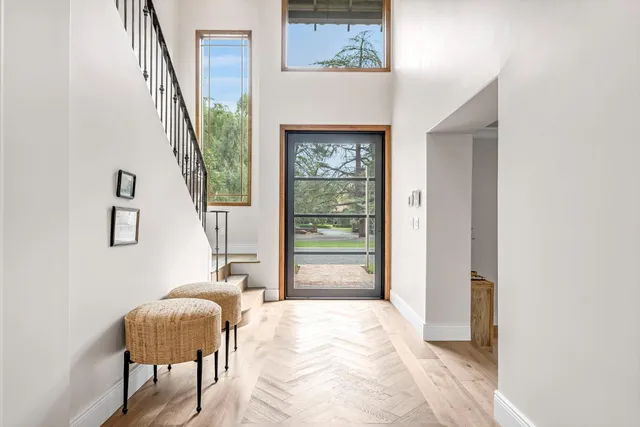 a view of a dining room and livingroom with furniture wooden floor a chandelier