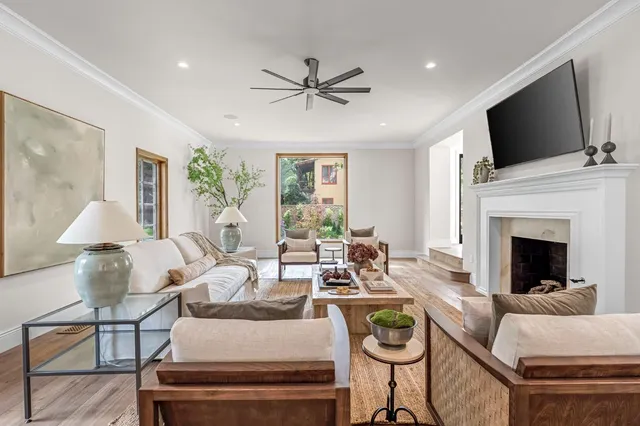 a dining room with wooden floor a chandelier a glass table and chairs