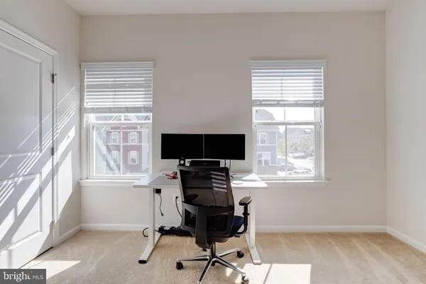 a view of a workspace with furniture and a window