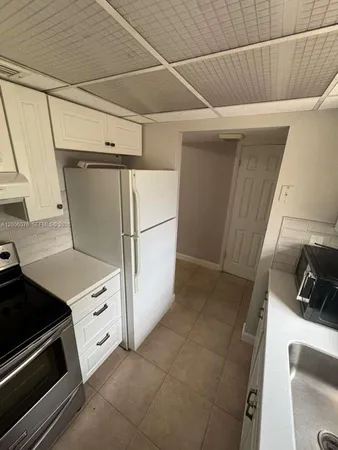 a view of a kitchen with a sink and a refrigerator