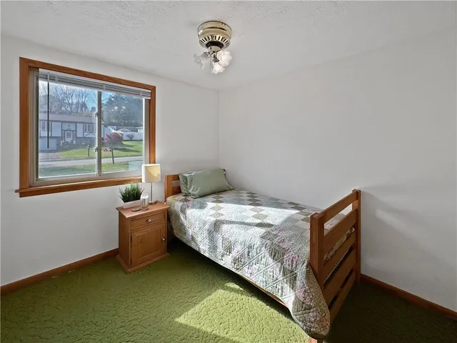 a bed sitting in a bedroom next to a window