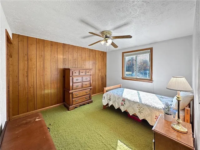 a spacious bedroom with a bed and a chandelier
