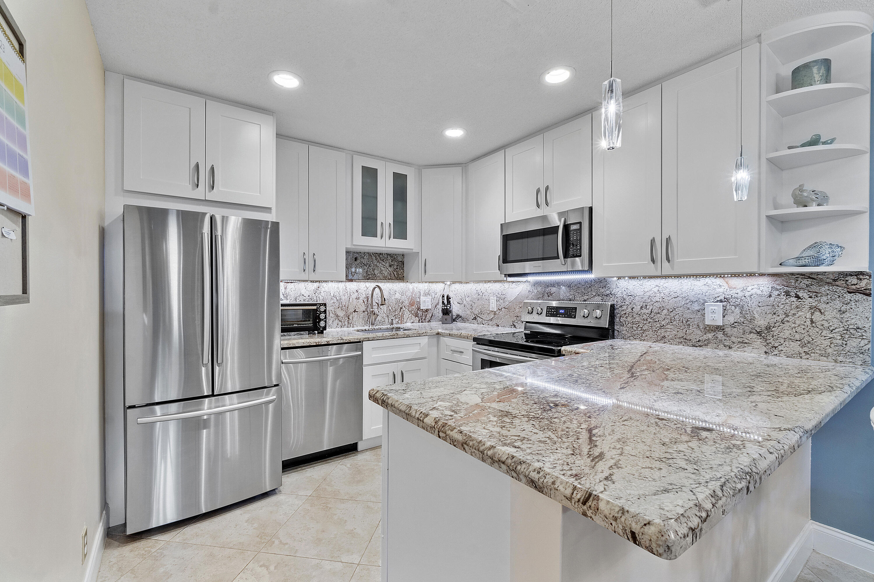 a kitchen with granite countertop stainless steel appliances and white cabinets