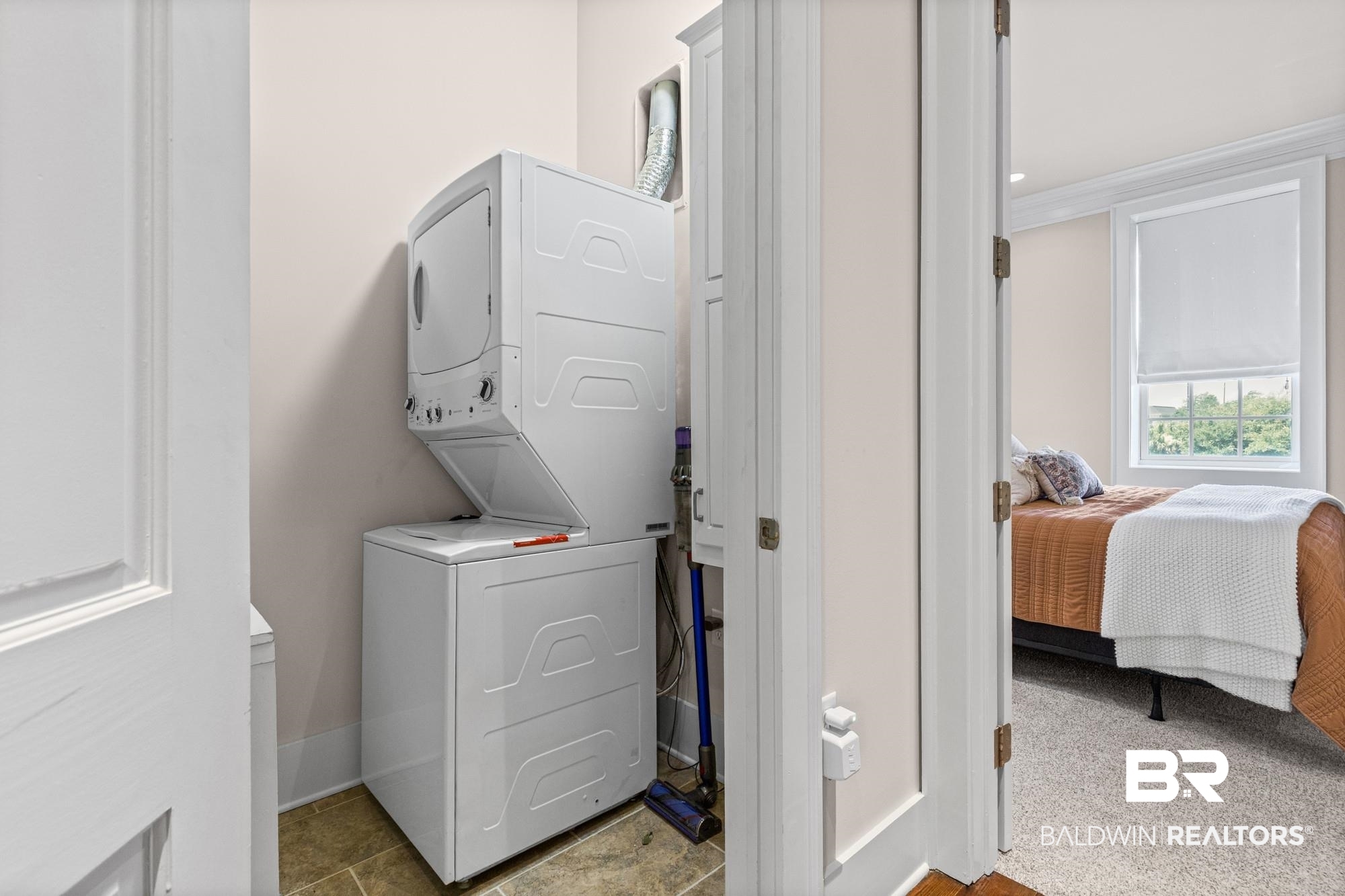 701 Dauphin Street, Unit A Mobile, AL 36602 - Photo 17 of 31 Dedicated laundry area featuring a stackable washer and dryer unit, complemented by neutral wall tones