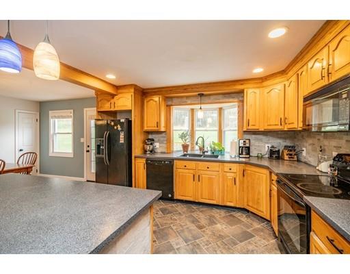 11 Enfield Road Pelham, MA 01002 - Photo 7 of 28 a kitchen with stainless steel appliances granite countertop a refrigerator a sink dishwasher a stove with wooden cabinets and dining table