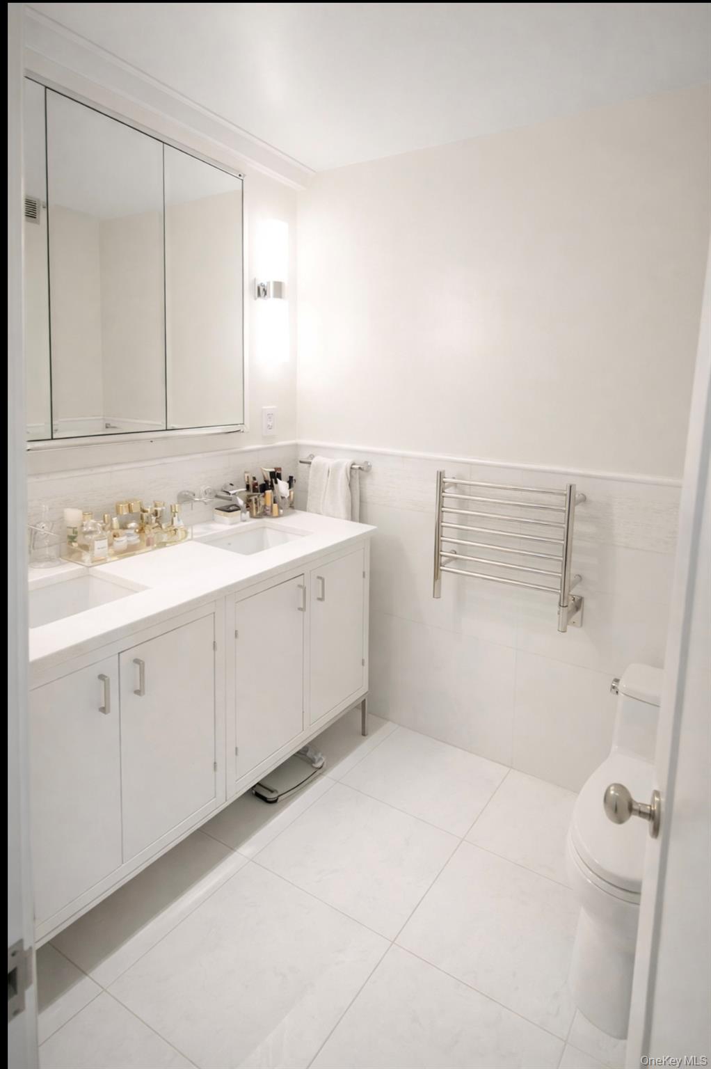 200 East 66th Street, Unit B1503 Manhattan, NY 10065 - Photo 12 of 24 a bathroom with a double vanity sink and mirror