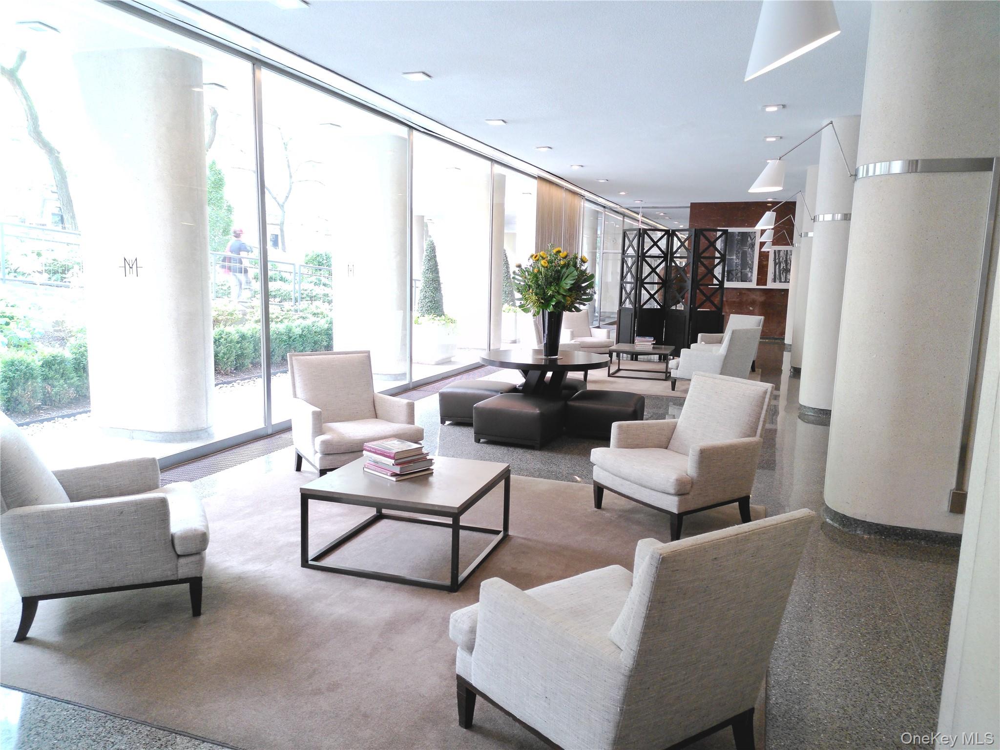 200 East 66th Street, Unit B1503 Manhattan, NY 10065 - Photo 18 of 24 a living room with furniture and a large window