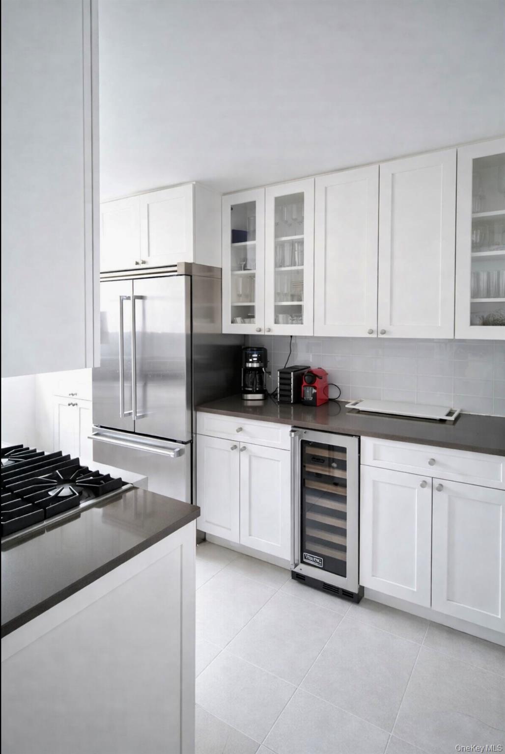 200 East 66th Street, Unit B1503 Manhattan, NY 10065 - Photo 8 of 24 a kitchen with granite countertop a stove a sink and a refrigerator