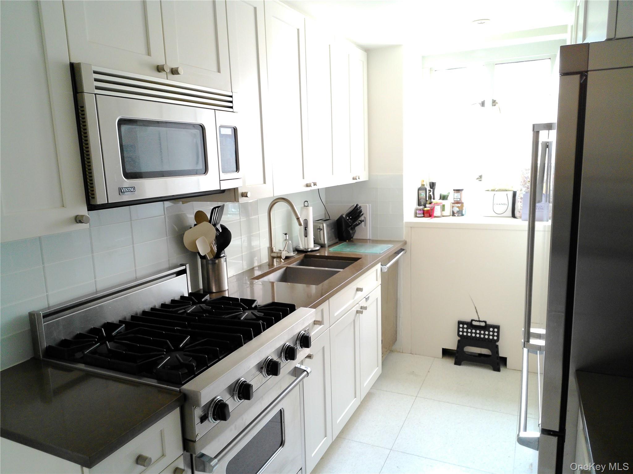 200 East 66th Street, Unit B1503 Manhattan, NY 10065 - Photo 10 of 24 a kitchen with a stove and a microwave