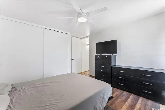 a bedroom with a bed and a flat tv screen on dresser