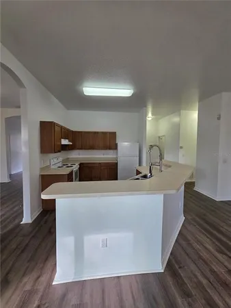 a large kitchen with stainless steel appliances a large counter top and a fireplace