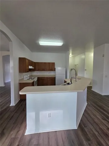 a large kitchen with stainless steel appliances a large counter top and a fireplace