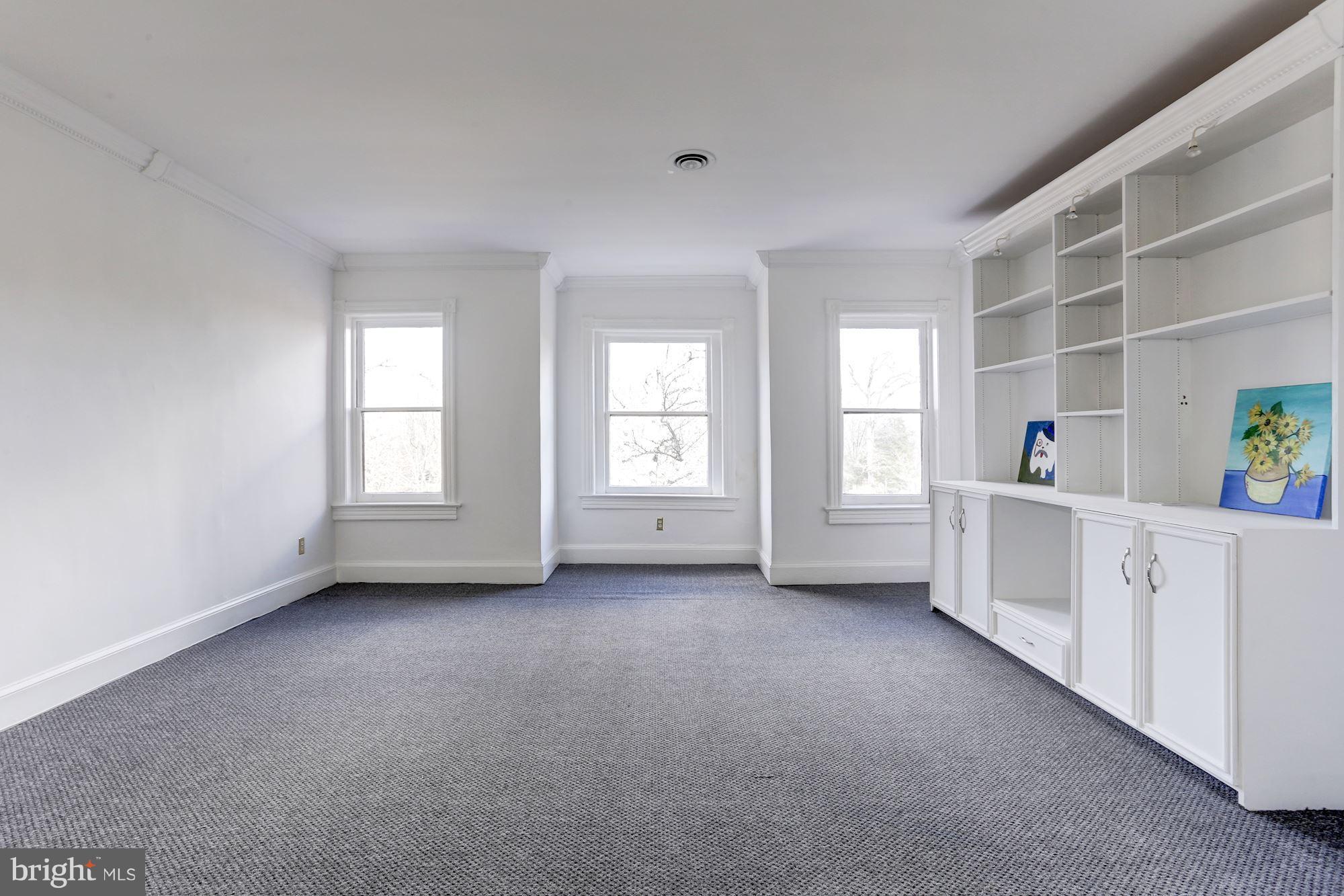 3022 R Street Northwest, Unit 3 Washington, DC 20007 - Photo 3 of 24 Living Room - with view of windows and bookcase.