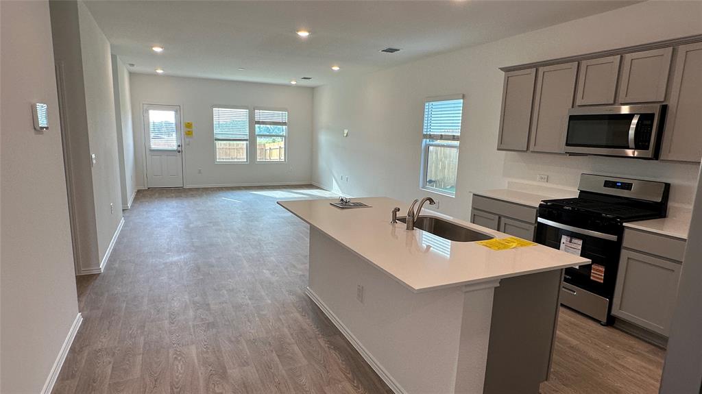 204 Inks Lane Kyle, TX 78640 - Photo 5 of 25 An open-concept living space with a pristine kitchen island and naturally illuminated areas throughout.