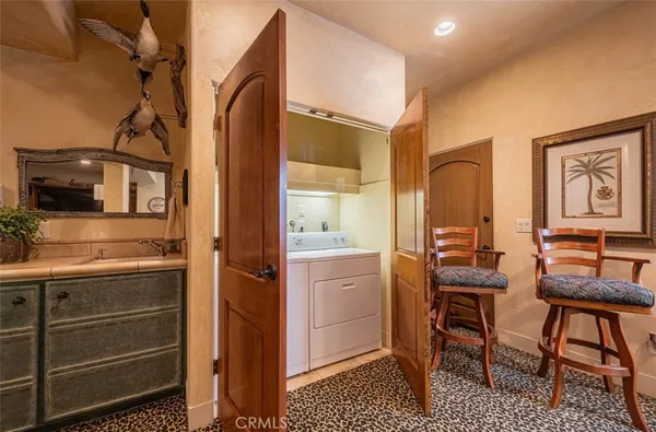 a spacious bedroom with a bed a dresser and a flat tv screen