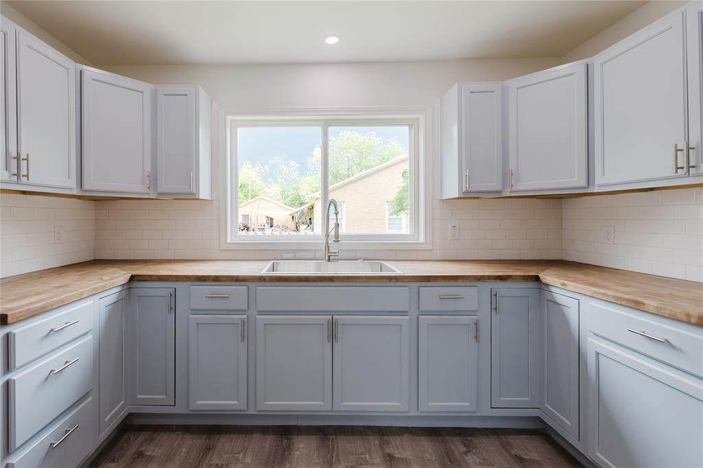 524 West Roberts Street Gorman, TX 76454 - Photo 9 of 35 a kitchen with granite countertop white cabinets and a window