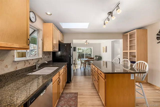 a kitchen with kitchen island a counter top space a sink stainless steel appliances and cabinets