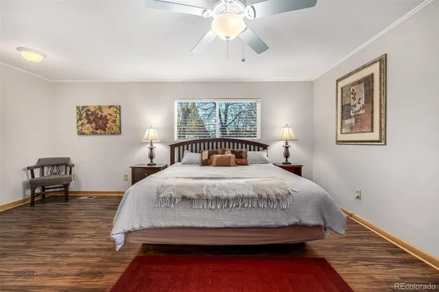 a bedroom with a large bed and wooden floor