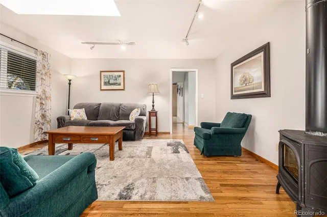 a kitchen with stainless steel appliances granite countertop a stove top oven a sink dishwasher a dining table and chairs with wooden floor