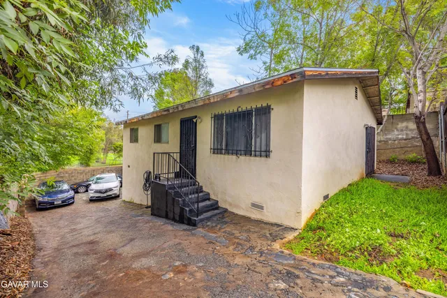 a view of a house with a wooden fence