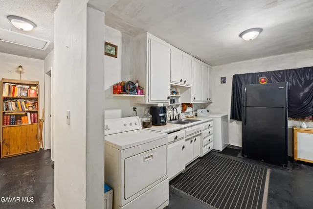a kitchen with white cabinets and refrigerator