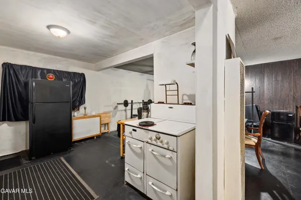 a kitchen with white cabinets and refrigerator