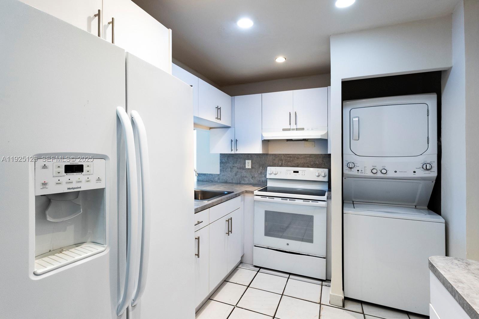460 East 23rd Street, Unit 302 Hialeah, FL 33013 - Photo 3 of 15 a kitchen with white cabinets and white appliances