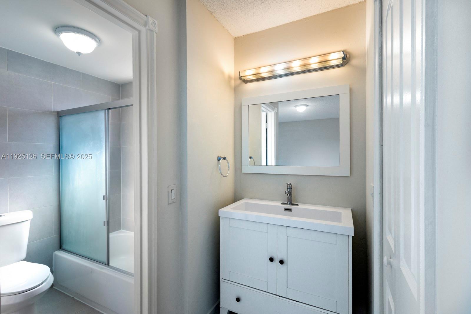 460 East 23rd Street, Unit 302 Hialeah, FL 33013 - Photo 10 of 15 a bathroom with a toilet a sink and mirror