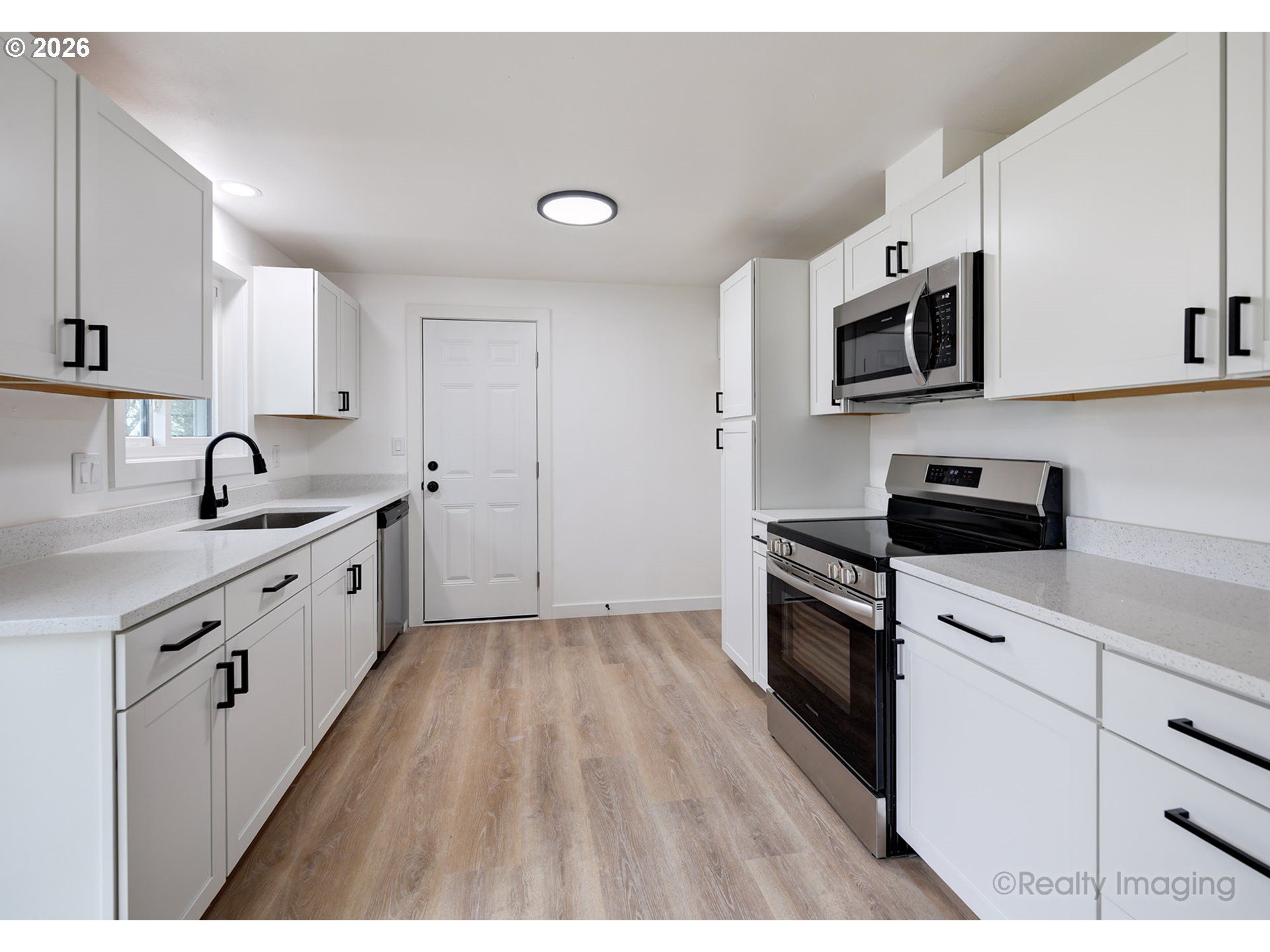 3075 Northeast Lancaster Street Corvallis, OR 97330 - Photo 6 of 13 a kitchen with white cabinets sink and stainless steel appliances