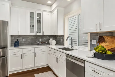 a kitchen with white cabinets and sink