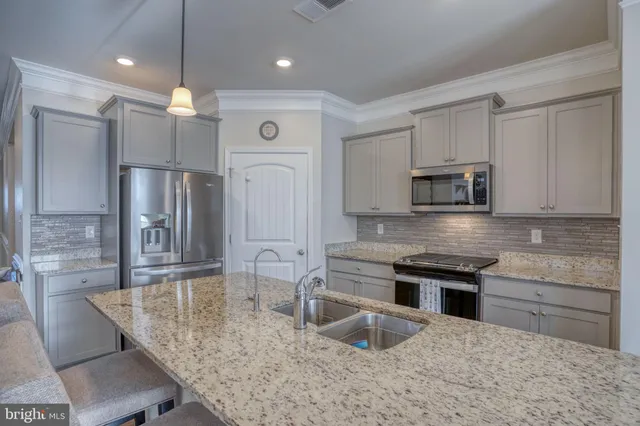 a kitchen with stainless steel appliances granite countertop a sink refrigerator and cabinets