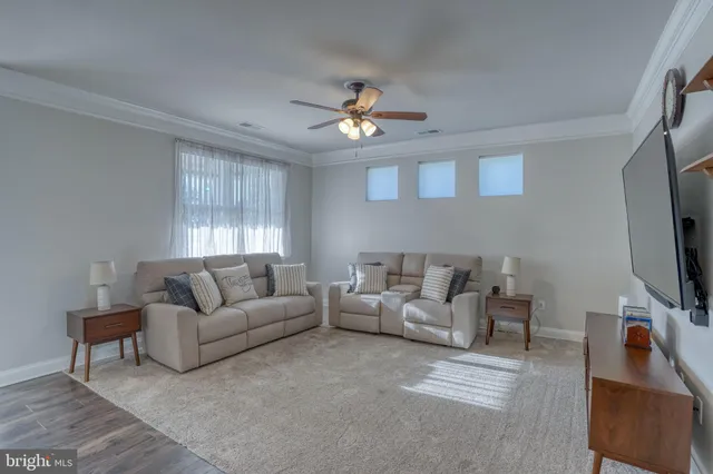 a living room with furniture a ceiling fan and a window