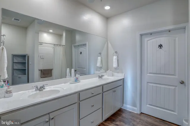 a bathroom with double vanity sinks and a mirror