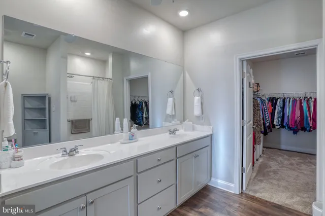 a en suite bathroom with a double vanity sink and a mirror