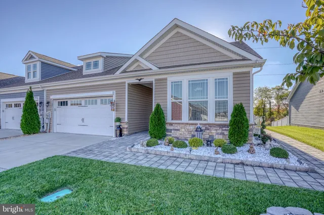 a front view of a house with a garden and plants