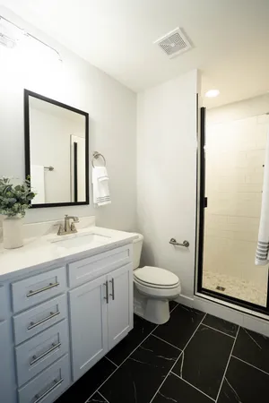 a bathroom with a toilet sink a mirror and shower
