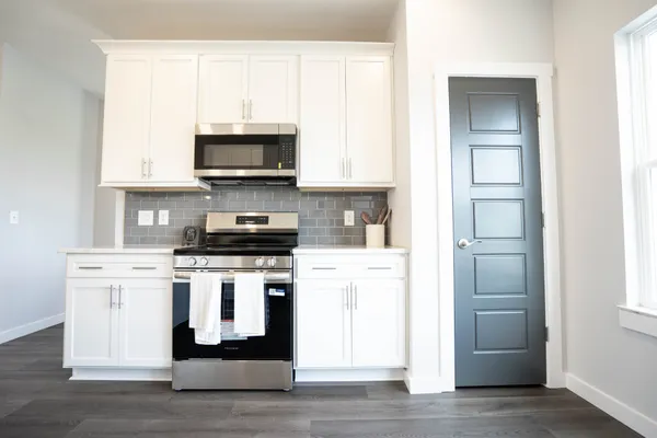 a kitchen with stainless steel appliances granite countertop a stove and a microwave